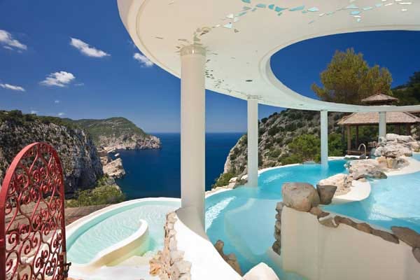 Direkt an der Steilküste im Nordwesten der Insel Ibiza liegt das Hotel Hacienda Na Xamena im Ferienort San Miguel. 180 Meter über dem Meeresspiegel, terrassenförmig in eine malerische Felslandschaft eingebettet, erstreckt sich das das 5-Sterne-Hotel mit seinen 77 Zimmern und Suiten.