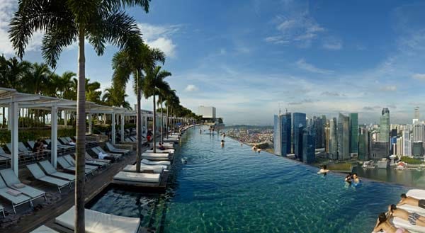 Das Fünf-Sterne-Hotel "Marina Bay Sands" liegt an der Marina Bay Promenade der Metropole Singapur. Auf dem 1,2 Hektar großen "SkyPark“ befindet sich ein Infinity-Pool mit einem 360-Grad-Blick über die Skyline von Singapur.