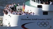Die deutschen Olympioniken schauen sich den grandiosen Empfang vom Deck aus an.