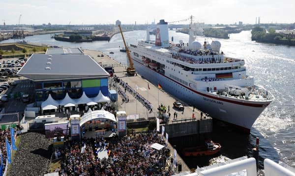 Die "MS Deutschland" legt am Hamburger Hafen an. Einige Meter weiter warten schon Hunderte Fans auf die Olympia-Helden.