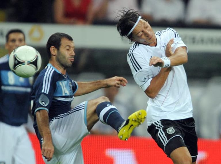 Mesut Özil köpft Javier Mascerano den Ball vor der Fußspitze weg.