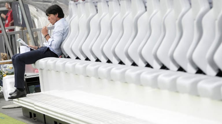Bundestrainer Joachim Löw als Bankdrücker. Vor dem Spiel gegen Argentinien geht er die letzten Informationen durch.
