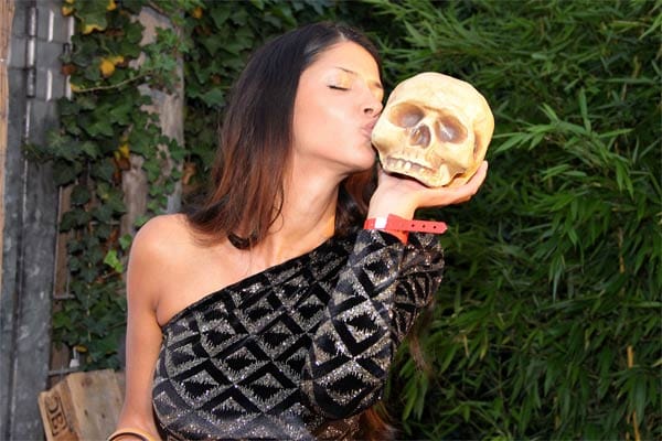 Micaela Schäfer küsst auf der Spielemesse Gamescom in Köln einen Totenschädel.