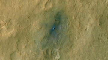 Rund eine Woche nach der Landung, zeigt die NASA das erste Bild des Rovers "Curiosity" auf dem Mars - sogar die Spuren der Landeraketen sind darauf zu erkennen. Das Bild ist eingefärbt, um die verschiedenen Gesteinssorten sichtbar zu machen. Der Rover ist als kleiner glänzender Punkt in dem blau eingefärbten Bereich zu sehen.