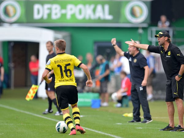 Kuba Blasczykowski läuft über die Außenbahn. Dortmunds Trainer Jürgen Klopp (re.) beschwert sich ebenso wie sein Kollege Peter Moussalli vom FC Oberneuland.