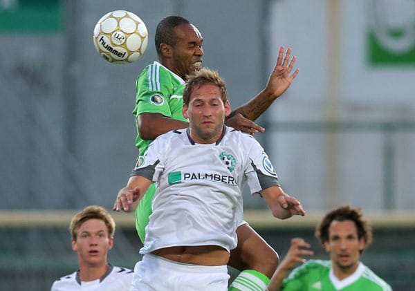 Schönbergs Bastian Henning (vorne) im Kopfballduell mit Wolfsburgs Naldo.