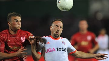 Augen auf: Franck Ribéry vom FC Bayern und der Regensburger Philipp Ziereis (li.) visieren den Ball an.