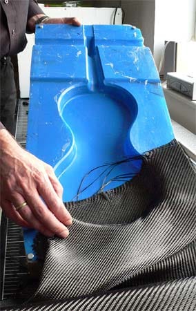 Hier wird eine Geigen-Form beim Bau eines Geigen-Corpus aus Carbon mit Faser-Kunsstoff ausgelegt.