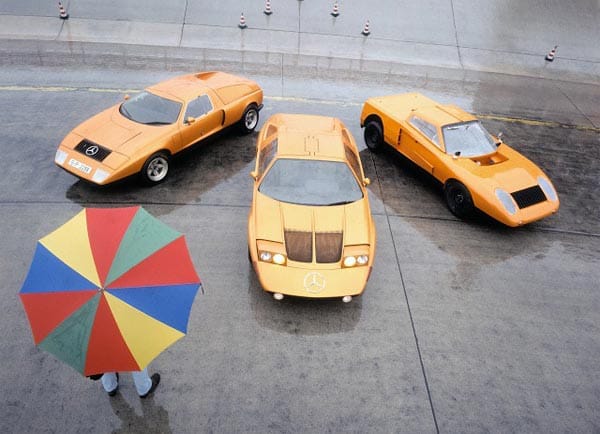 Die psychedelische Farbgebung der 1970er Jahre spiegelt sich in diesem Foto, das drei Generationen des C 111 in der berühmten Lackierung „Weißherbst“ vereint: Links steht der 1969 auf der IAA präsentierte C 111/I, in der Mitte ist der C 111/II mit 4-Scheiben-Wankelmotor von 1970 zu sehen, rechts die wegen ihres kantigen Designs auch „Hobel“ genannte erste Prototypen-Version.