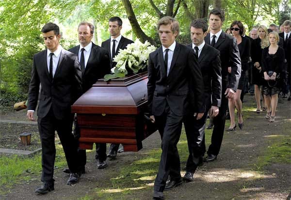Bei Arnos Beerdigung tragen ihn Freunde und Angehörige gemeinsam zu Grabe.