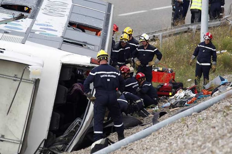 Helfer bergen Menschen aus einem Reisebus, der auf der A 36 bei Mulhouse in Frankreich verunglückt ist.