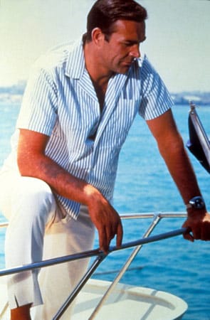 Natürlich fühlt sich 007 auch auf einer Jacht wohl. Passend dazu zeigt er sich ganz maritim in weißer Bundfaltenhose und gestreiftem Hemd.