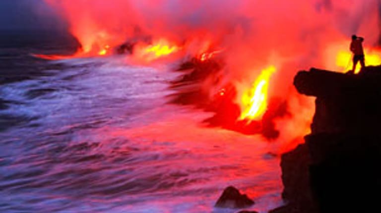 Glutküste: Mit der Geschwindigkeit eines gemütlichen Radfahrers strömt die Lava im Süden der Hauptinsel von Hawaii die Felsen hinab - bevor sie in dampfendem Inferno aufgeht.