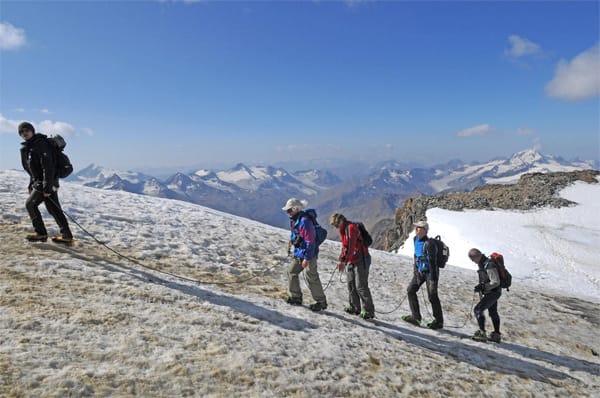 Ein erfahrener Bergführer führt Touristen auf den Gipfel.