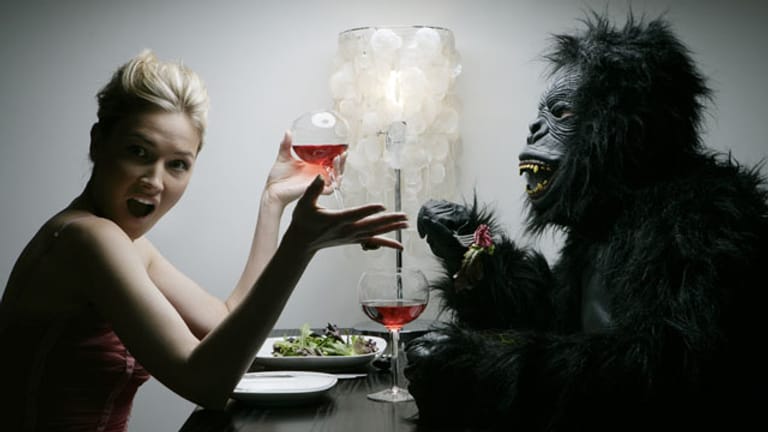 Frau mit Mann in Gorilla-Kostüm am Tisch