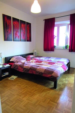 In diesem mit warmen Rottönen dekorierten Schlafzimmer können sich beide wohlfühlen. Und die Bettwäsche darf ruhig ein blumiges Pendant zum Wechseln haben.
