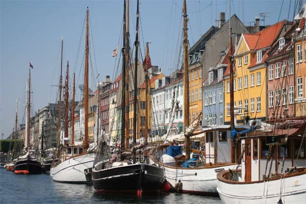Blick auf Boote am Anleger und Gebäude am Neuen Hafen in der dänischen Hauptstadt Kopenhagen.