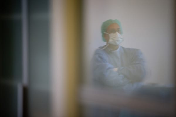Zakarya El Sesiy aus Ägypten spiegelt sich bei der Beschneidung seines zweijährigen Sohnes in der Tür zum Operationssaal in einer Berliner Privatklinik.