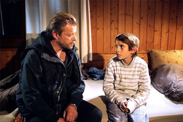 Der Schweizer Ermittler Roland Koch (Matteo Lüthi) befragt Moritz (Elia Sager), der mit dem ermordeten Jungen in einem Zimmer wohnte.