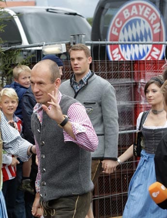 Arjen Robben (li.) ist nach überstandenen muskulären Problemen und kurzer Pause auf der Theresienwiese anzutreffen. Im Hintergrund läuft Manuel Neuer Hand in Hand mit Freundin Kathrin.