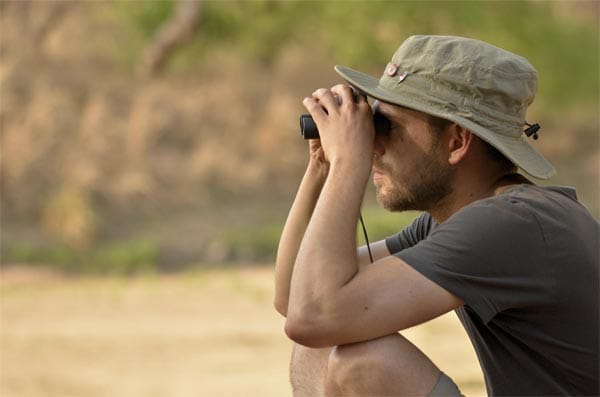 Tourist mit Fernglas bei der Tierbeobachtung in Kamerun.