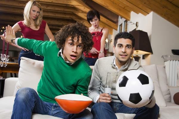 Männer und Fußball - hier sind sogar gleich zwei Auslöser für einen Streit zu finden. Entweder fühlt sich der Partner vom Lärm des Fernsehers gestört oder vernachlässigt.