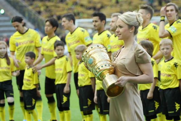 Im Finale um den DFB-Pokal zwischen Borussia Dortmund und dem FC Bayern München schreitet Magdalena Neuner mit dem Pokal voran auf den Platz des Olympiastadions in Berlin.