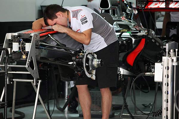 Ein McLaren-Mechaniker wirft erste prüfende Blicke auf die Boliden.