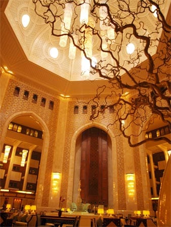 Das Al Bustan Palace wurde bereits in den 1970er Jahren, zum Teil als Gästehaus des Sultans konzipiert und zum Prototyp moderner Luxushotels des Arabischen Raums, wie des Emirates Palace in Abu Dhabi. Seit kurzem ist es unter dem bewährten Management von Ritz-Carton. Geblieben ist das spektakuläre Atrium mit viel Marmor, echtem Gold und der 38 m hohen Kuppel inklusive Kronleuchter.