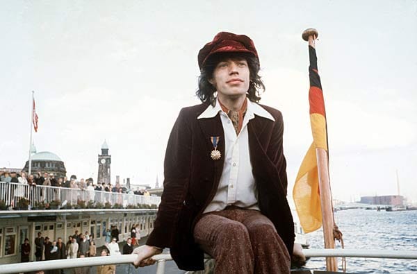 Dieses Bild zeigt Mick Jagger, den Boss und Sänger der Rolling Stones, bei einem seiner Deutschlandbesuche. Er sitzt auf der Reling eines Elbdampfers an den Landungsbrücken in Hamburg 1970.