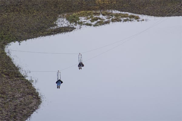 Rappbodetalsperre: Zwei Männer fahren mit der längsten Doppelseilrutsche Europas im Harz.