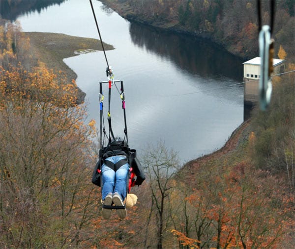 Mann fährt mit der längsten Doppelseilrutsche Europas im Harz.