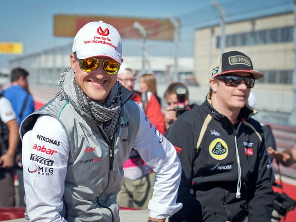 Michael Schumachers (li.) Pech hat sich nun auch auf die Fahrerparade ausgebreitet. Weil sein Mustang nicht angesprungen ist, muss er bei Kimi Räikkönen mitfahren. Lächeln kann er trotzdem noch.