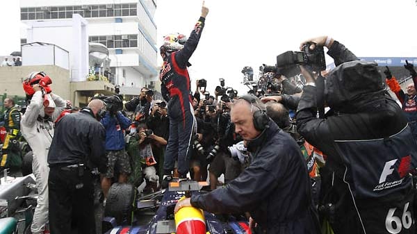 Der 25-Jährige hat es geschafft. Nach dem Rennen steigt er auf seinen Formel-1-Boliden und hebt den Vettel-Finger. Michael Schumacher (li.) zieht erst einmal seinen Helm aus.