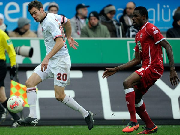 St. Paulis Sebastian Schachten (li.) macht sich mit Ball auf und davon. Kaiserslauterns Knipser Mohamadou Idrissou kommt zu spät.