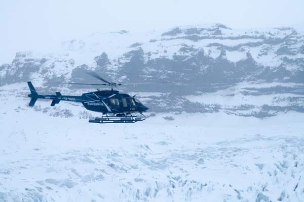 Nach etwa fünf Minuten dreht der Hubschrauber in Richtung der fast 2000 Meter hohen Gipfel des Gletschergebiets ab. "Jetzt spielen wir Achterbahn", erklärt der Pilot lachend, dessen ellenlangen, isländischen Namen, man kaum aussprechen kann. In höchstens zwanzig Metern Höhe fliegt er über eine atemberaubende Landschaft aus Eis, Schnee, gigantischen Gipfeln, Gletscherspalten und riesigen Wasserfällen.