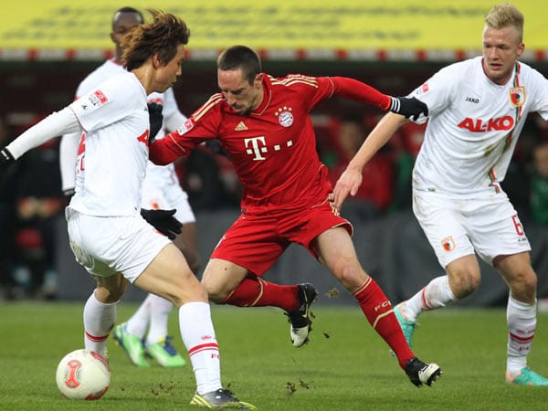 Der FC Bayern lässt auch im Derby beim FC Augsburg keine Punkte liegen. Hier tunnelt Franck Ribéry Augsburgs Ja-Cheol Koo (li.).
