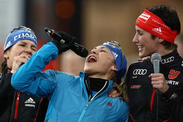 Neuner gibt nach dem Rennen zusammen mit den deutschen Biathletinnen Kathrin Lang (li.) und Sabrina Buchholz ein Lied zum Besten.
