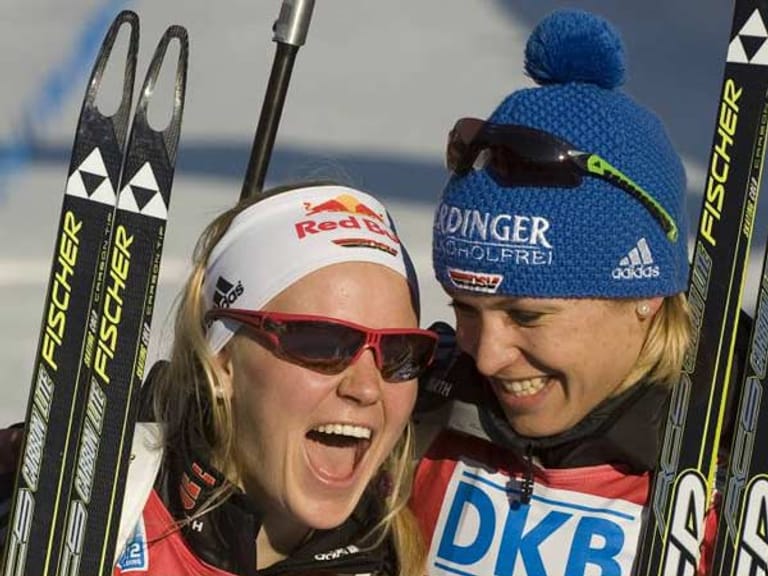 Während Andrea Henkel als Schlussläuferin der Staffel mit großem Vorsprung auf der Strecke ist, freuen sich Gössner (li.) und Neuner am Streckenrand bereits auf die Goldmedaille.