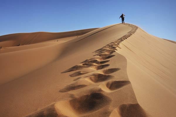Wanderer auf einer Düne in der Wüste.