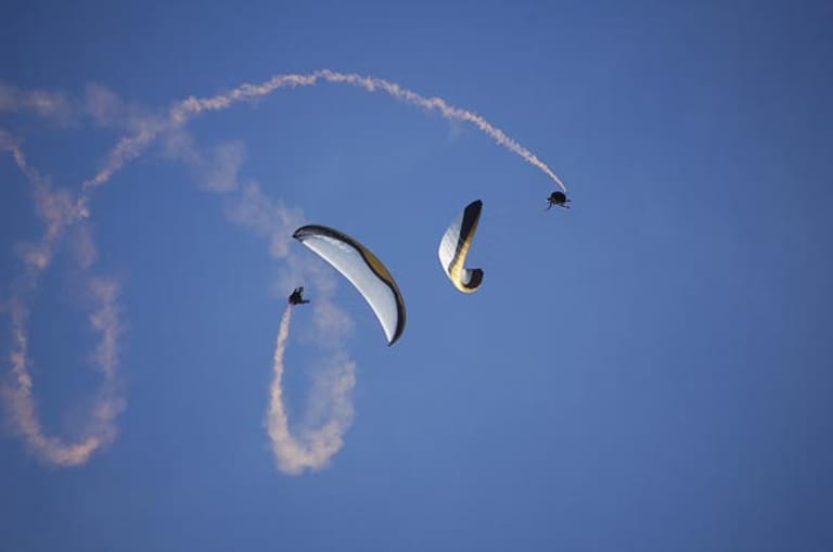 Gleitschirm-Akrobatiker führen Flugfiguren aus