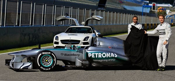 Die beiden Mercedes-GP-Stammfahrer Lewis Hamilton (li.) und Nico Rosberg ziehen die schwarze Plane vom F1 W04.