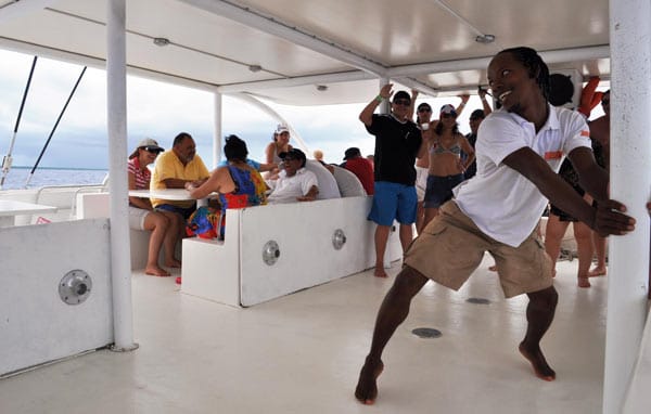 Auf dem Katamaran zur Insel Saona fordert ein Animateur die Touristen zum Tanzen auf.