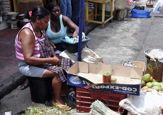 Frauen pulen Erbsen auf dem Markt im Stadtteil Klein Haiti, Santo Domingo.