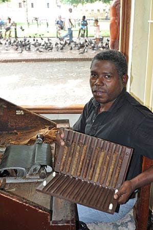In einem Geschäft in Santo Domingo rollt ein Mitarbeiter Zigarren.