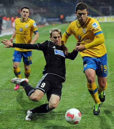 Während der Braunschweiger Ken Reichel (re.) Aalens Robert Lechleiter zu Boden ringt, kann dieser den Ball noch per Flanke loswerden.