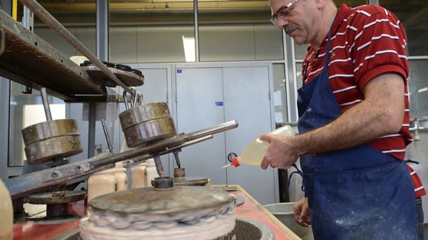 Ein Mitarbeiter der Jos. Schneider Optische Werke GmbH poliert im Stammwerk in Bad Kreuznach Linsen fuer Spezialaobjektive