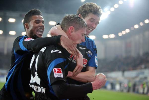 Paderborns Torschütze zum 1:0 Tobias Feisthammel (mi.) wird von seinen Teamkollegen Elias Kachunga (l) und Patrick Ziegler bejubelt.