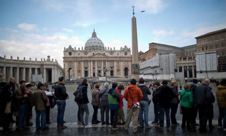 Besucher warten auf dem Petersplatz im Vatikan in Rom in einer langen Reihe auf den Besuch des Petersdoms.