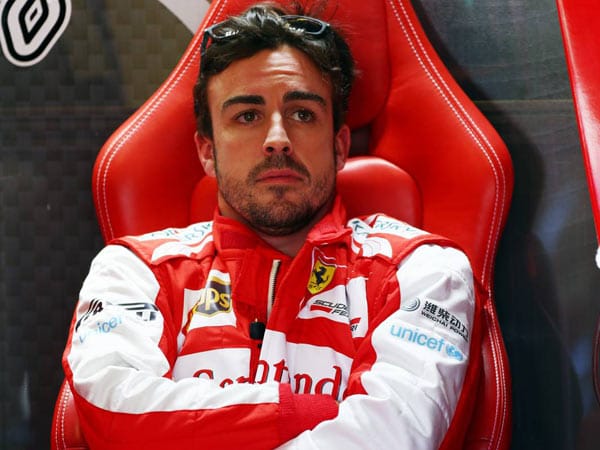 Mit lässigem Blick sitzt Fernando Alonso in der Boxengasse.